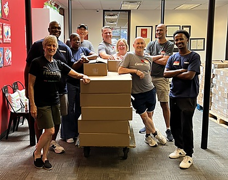Dallas BEST Robotics volunteers gathered around a cart of kit boxes